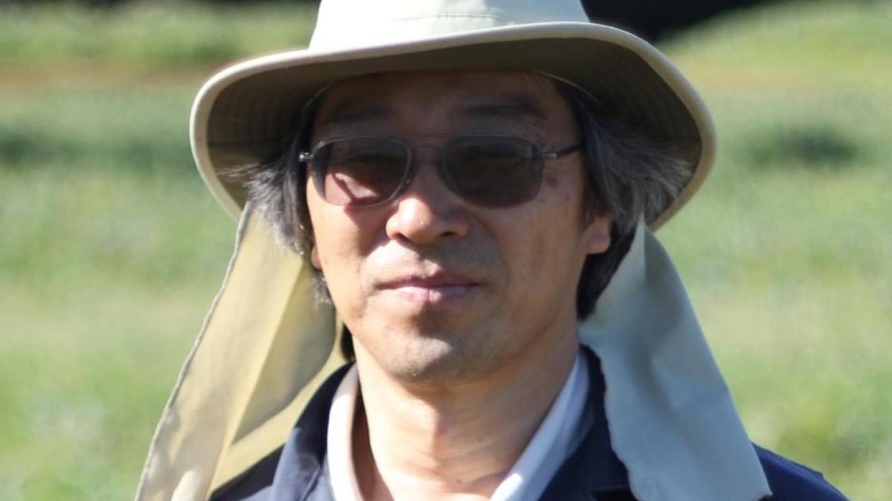 Joji Muramoto outdoors in a field