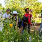 student leads kids in the garden