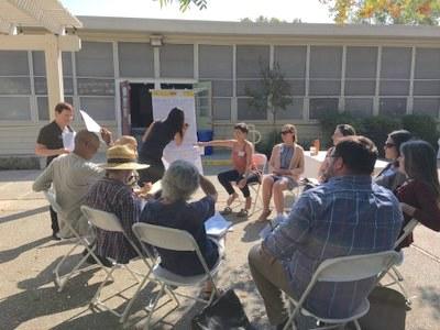 a group of people sitting on chairs in the sun